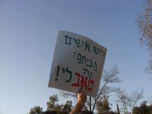 A protester holds a sign that reads-- expelling people from houses: it hurts me!